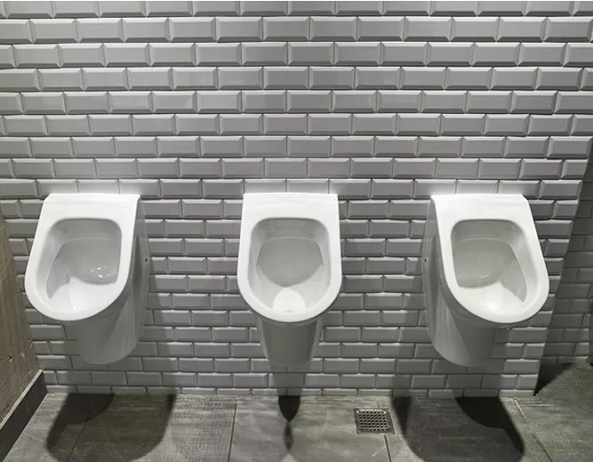 Row of Water saving urinals on white tiles