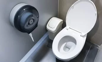 Cubicle with toilet, toilet paper and bin