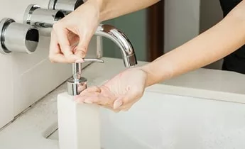 Hands washing with soap at basin