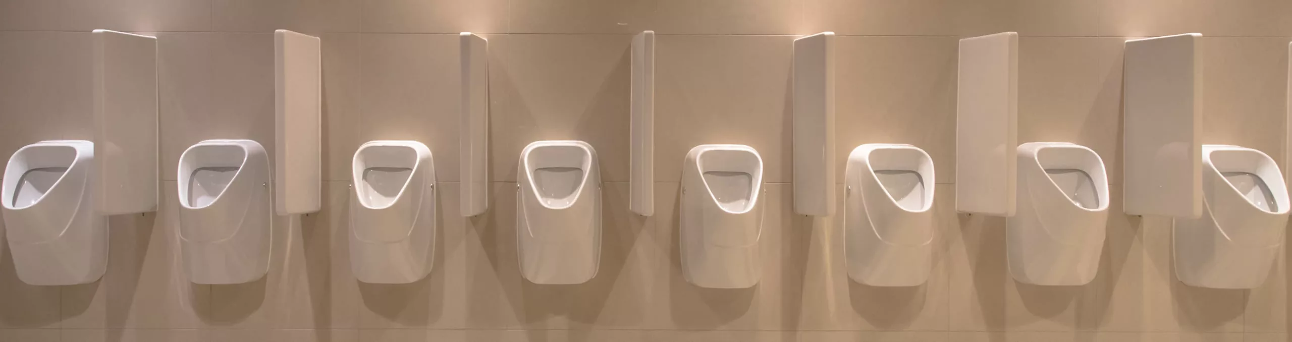 Row of urinals on white tiles