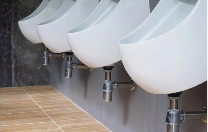 row of urinals on grey tiles